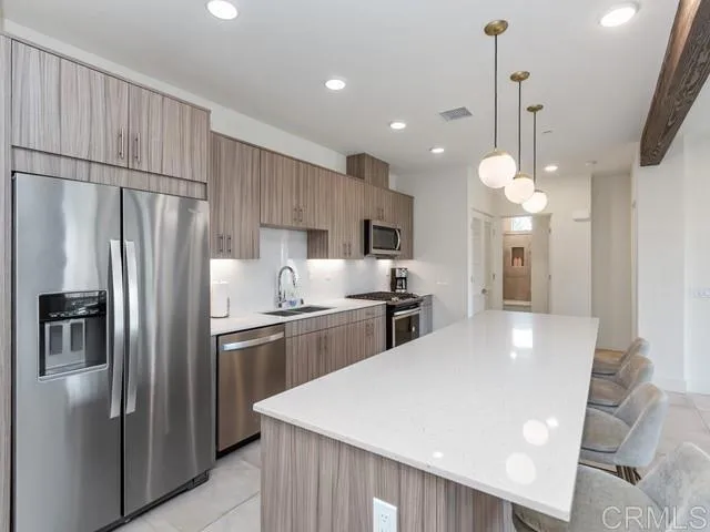 a kitchen with stainless steel appliances a refrigerator sink and stove