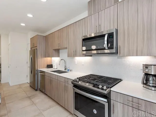 a kitchen with granite countertop a stove sink and microwave