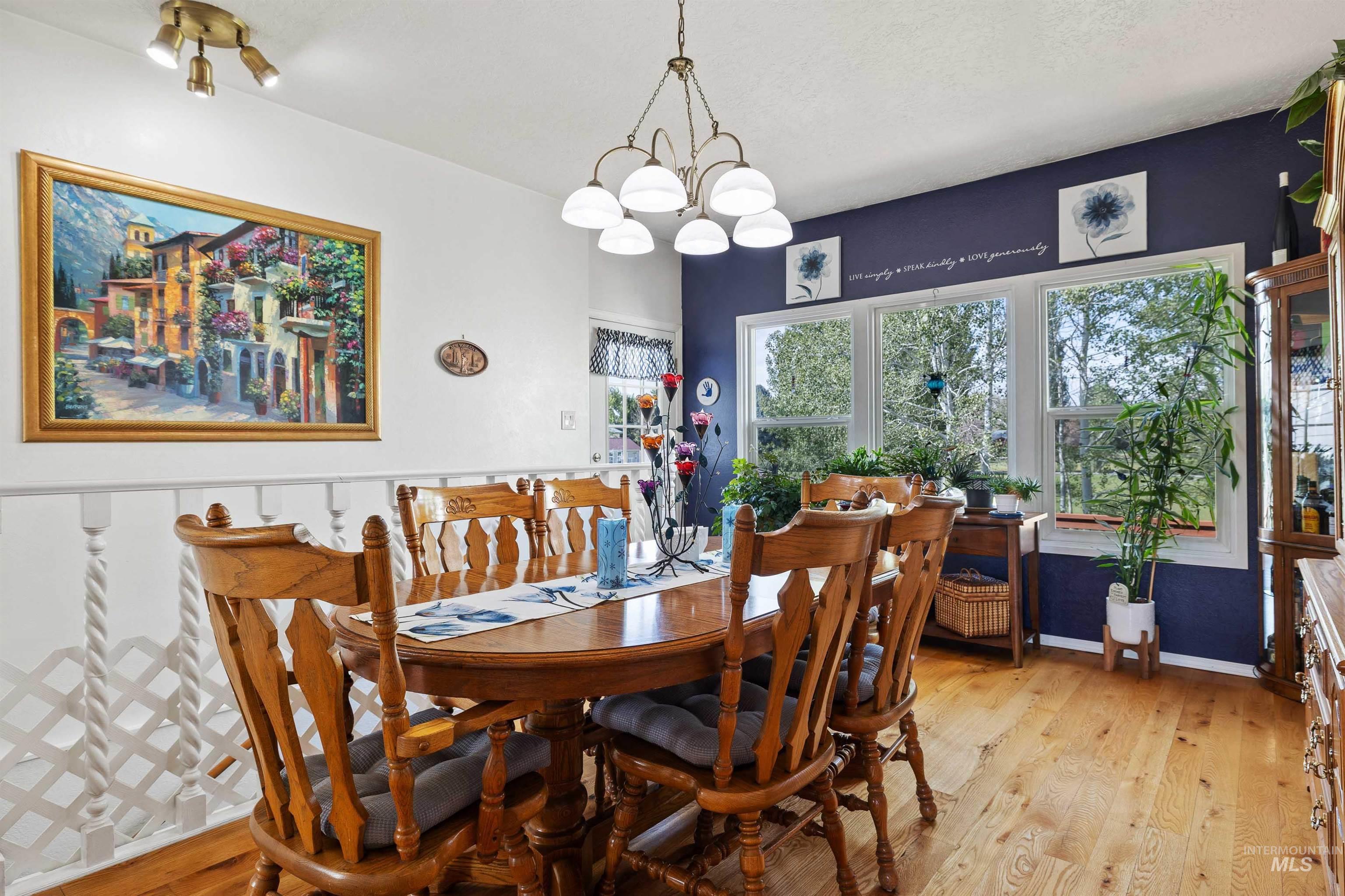 216 Ranch View Road West Jerome, ID 83338 - Photo 13 of 42 Hardwood flooring, painted accent wall, white trim, track lighting, and a decorative chandelier