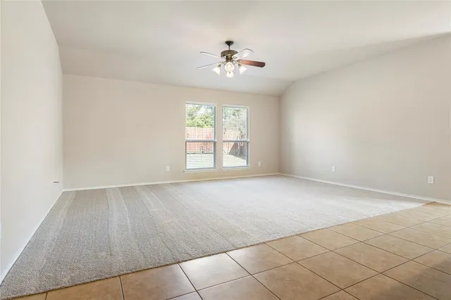a view of a livingroom with furniture a kitchen view and a chandelier