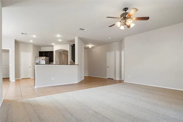 an empty room with windows and ceiling fan
