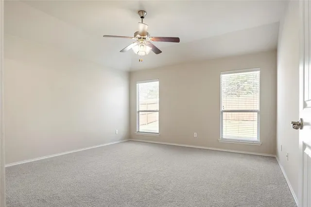 an empty room with closet and a ceiling fan