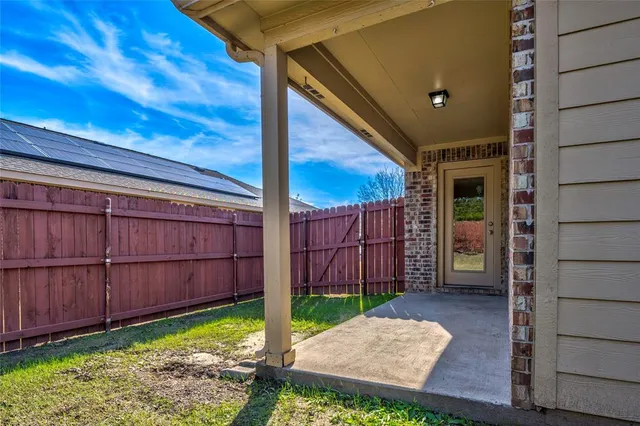 a view of backyard with wooden fence