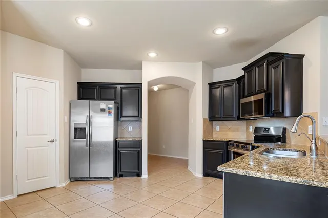 a view of a kitchen with a sink and refrigerator in kitchen