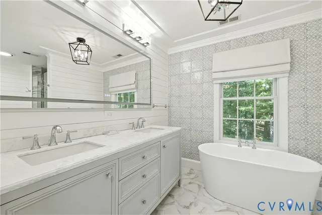 a bathroom with a bathtub a sink a mirror and a window