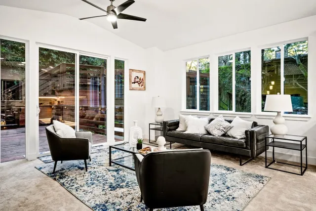 a living room with furniture and floor to ceiling windows