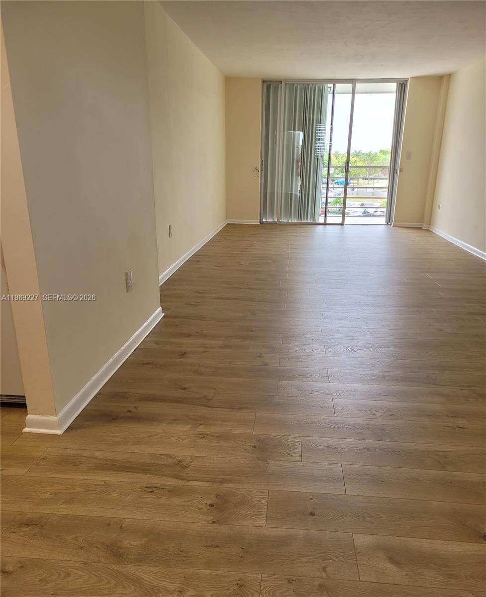 14140 Southwest 84th Street, Unit 301H Miami, FL 33183 - Photo 14 of 39 a view of an empty room with wooden floor and a window