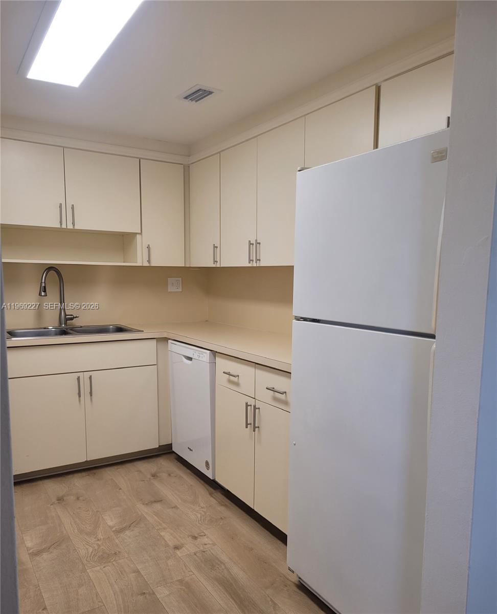14140 Southwest 84th Street, Unit 301H Miami, FL 33183 - Photo 21 of 39 a kitchen with white cabinets and white stainless steel appliances