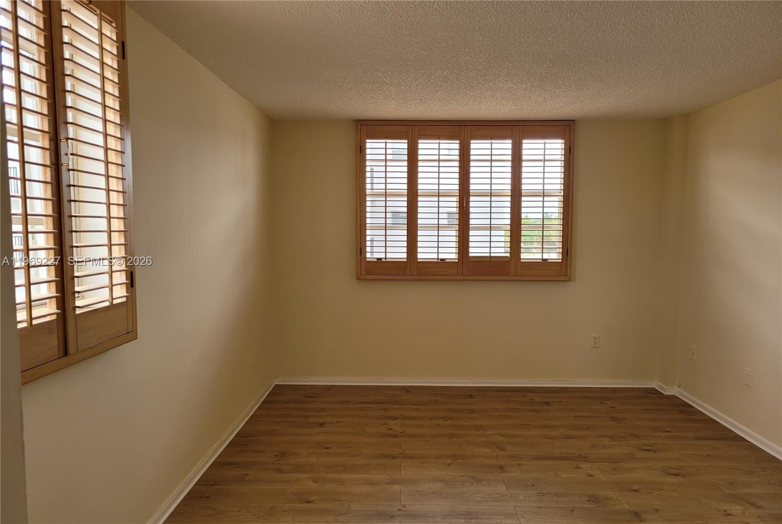 14140 Southwest 84th Street, Unit 301H Miami, FL 33183 - Photo 27 of 39 a view of an empty room with wooden floor and a window