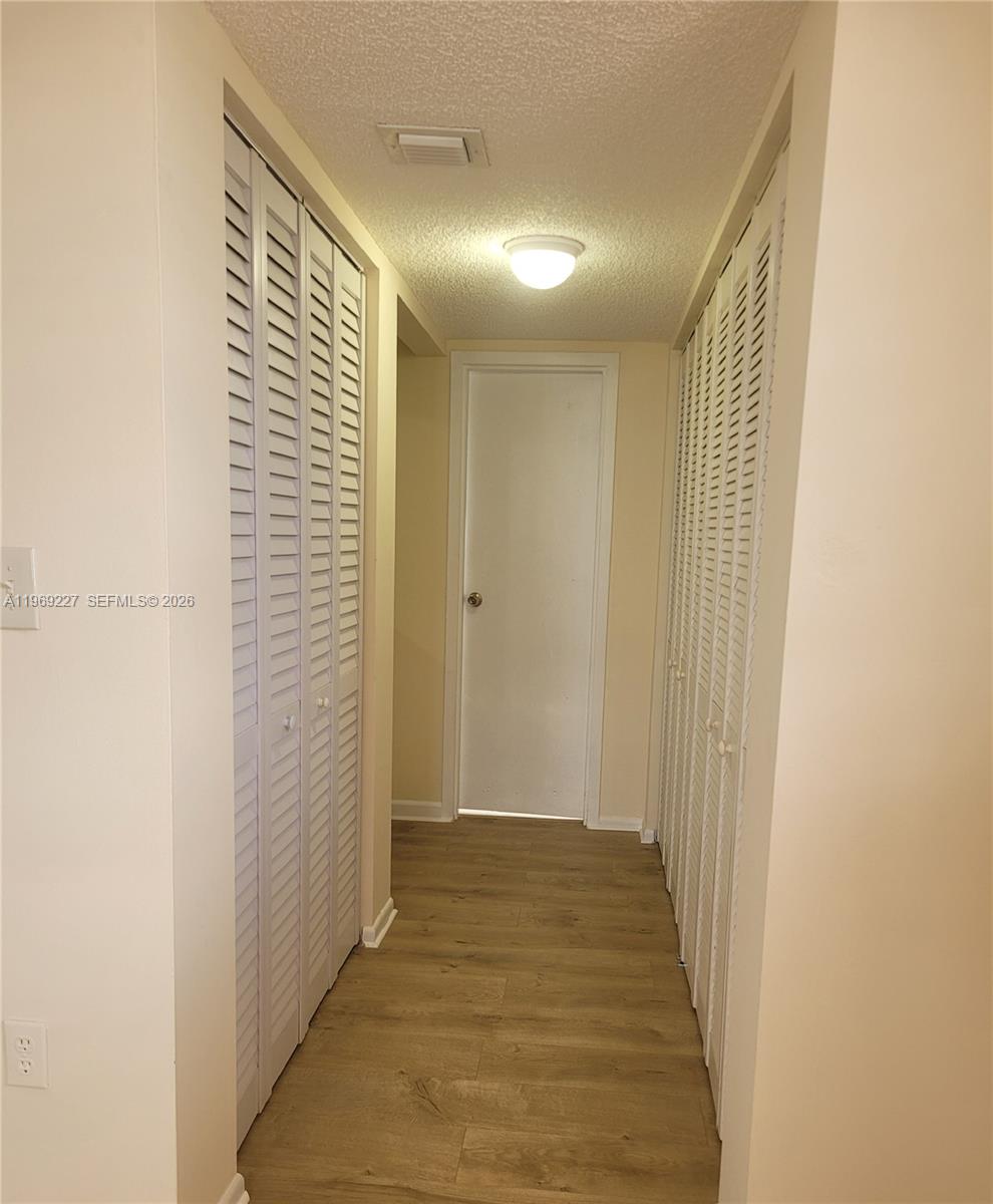 14140 Southwest 84th Street, Unit 301H Miami, FL 33183 - Photo 30 of 39 a view of a hallway with wooden floor and a bathroom