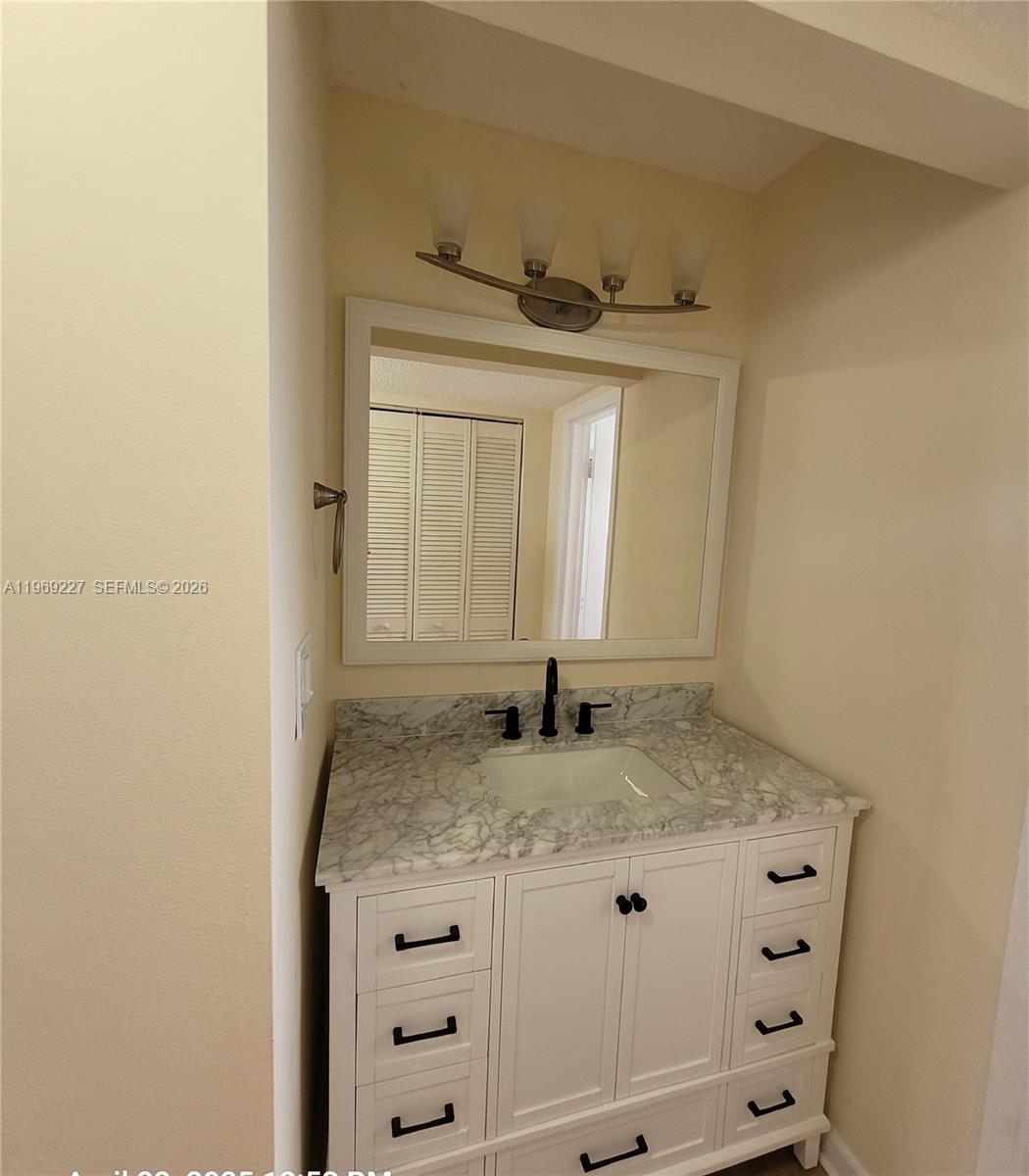 14140 Southwest 84th Street, Unit 301H Miami, FL 33183 - Photo 31 of 39 a bathroom with a granite countertop sink and a mirror