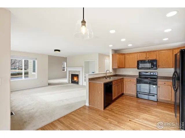 a kitchen with stainless steel appliances a stove top oven a sink a refrigerator and cabinets