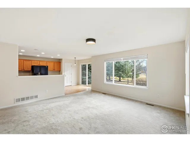 a view of an empty room with a fireplace and a window