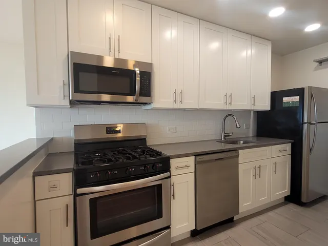 a kitchen with stainless steel appliances granite countertop a stove a microwave and a refrigerator