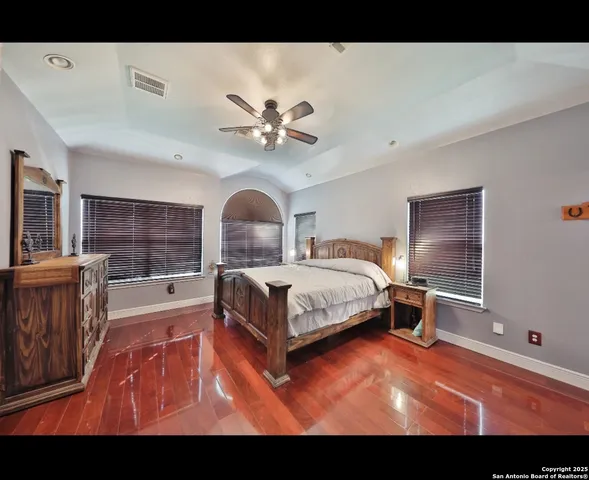 a bedroom with a large bed and a chandelier
