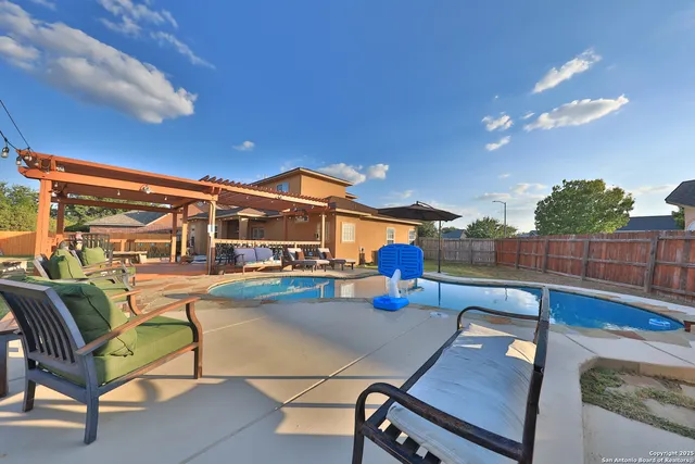 a view of a patio with couches table and chairs with wooden floor and fence
