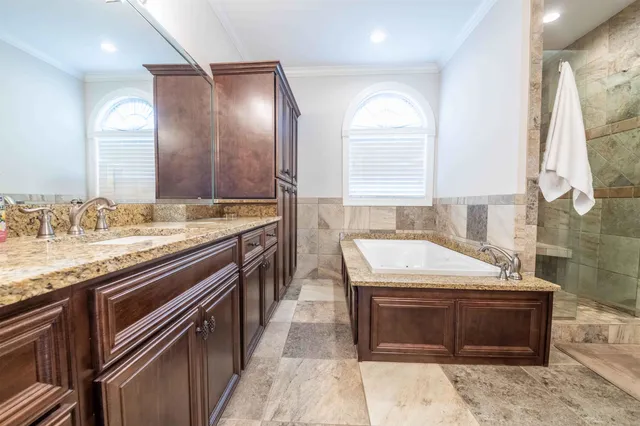a bathroom with a granite countertop sink a mirror and a bathtub