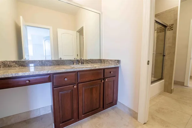 a bathroom with a granite countertop sink and a mirror