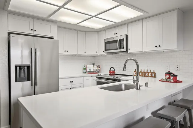 a kitchen with stainless steel appliances a refrigerator sink and cabinets