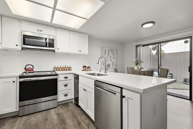 a kitchen with stainless steel appliances white cabinets and sink