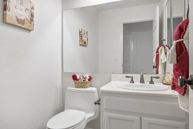 a bathroom with a sink mirror and toilet