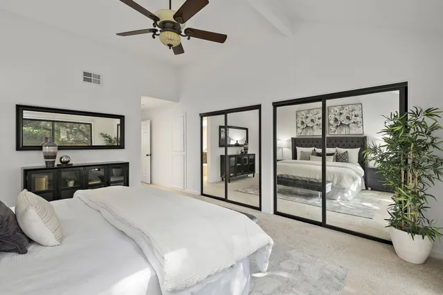 a bedroom with a large bed and a flat tv screen