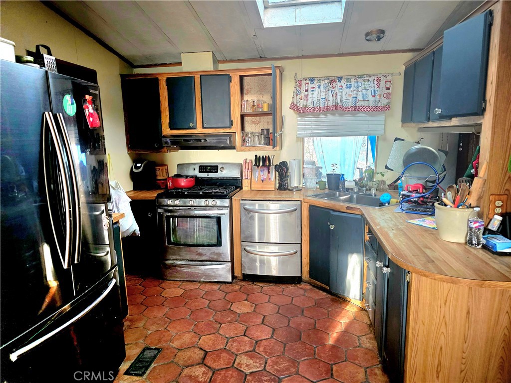 10623 Desert View Road Pinon Hills, CA 92372 - Photo 11 of 76 a kitchen with stainless steel appliances a stove sink refrigerator and cabinets