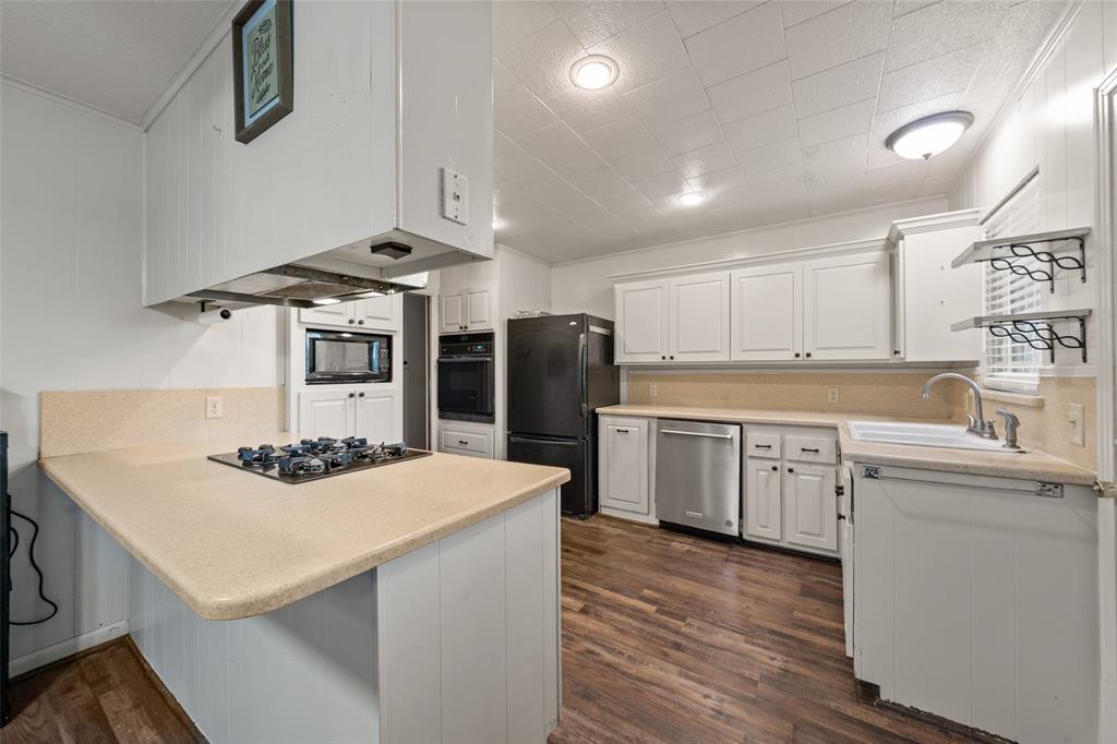 608 West Spring Street West, TX 76691 - Photo 8 of 27 a kitchen with a sink a stove and refrigerator