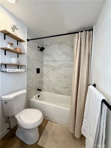 a kitchen with stainless steel appliances white cabinets and a stove a refrigerator with wooden floor