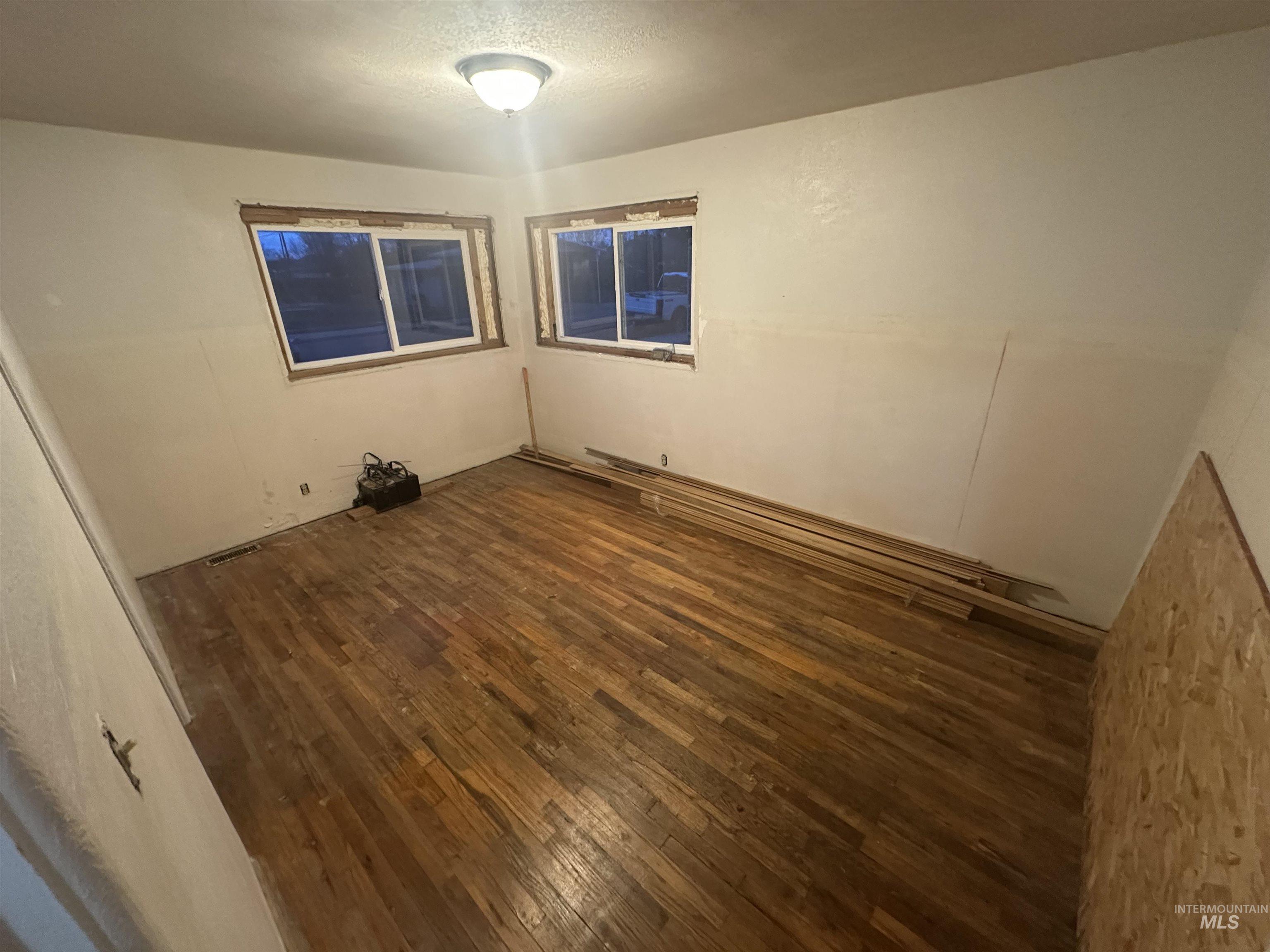 410 South Yakima Street Vale, OR 97918 - Photo 12 of 29 Spare room with dark wood-type flooring and a textured ceiling