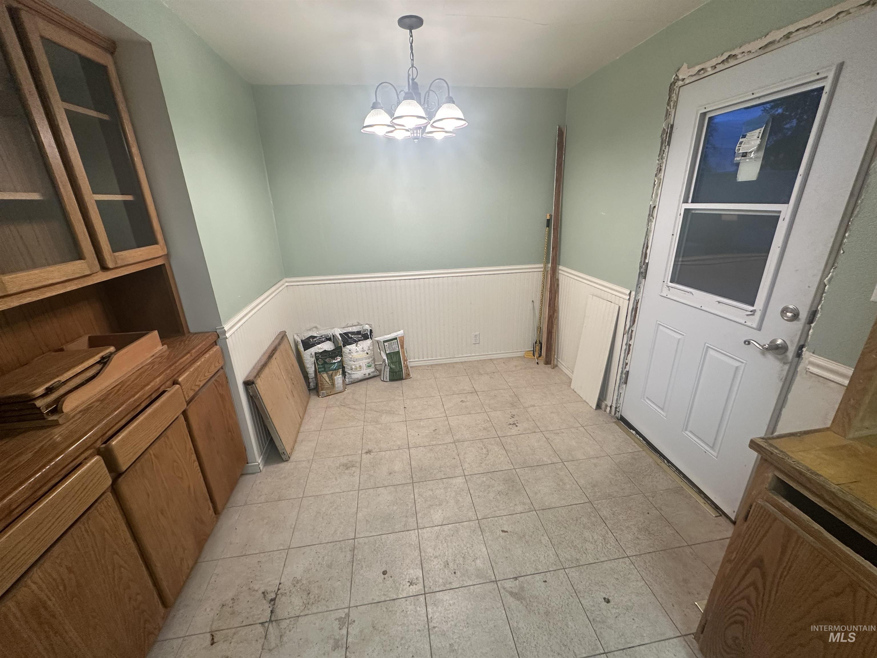 410 South Yakima Street Vale, OR 97918 - Photo 6 of 29 Unfurnished dining area with a wainscoted wall and a chandelier