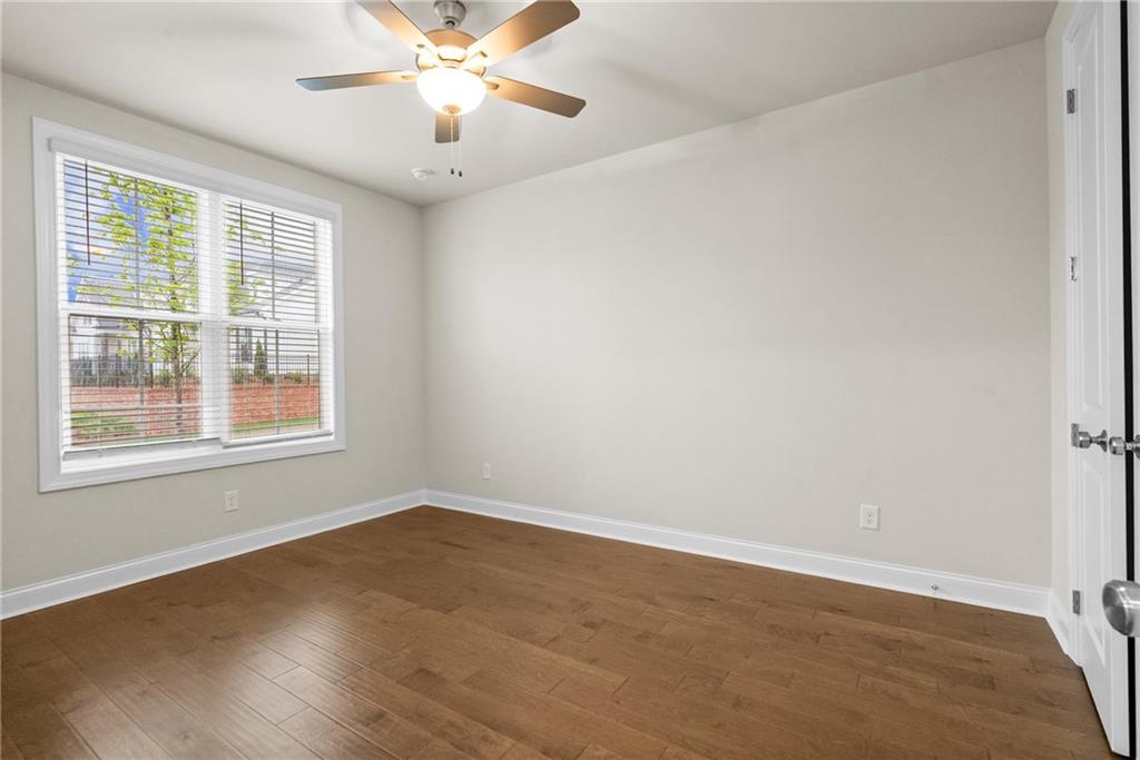 579 Pearl Street Cumming, GA 30040 - Photo 12 of 30 a view of an empty room with wooden floor and a window