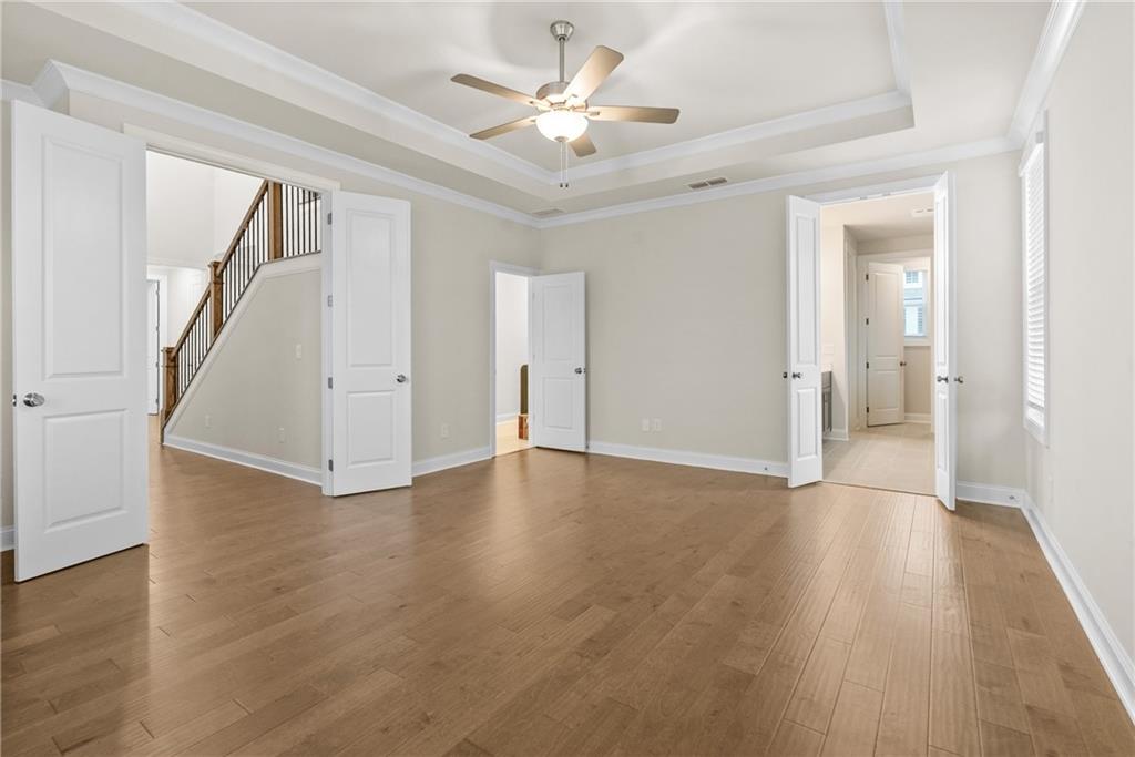 579 Pearl Street Cumming, GA 30040 - Photo 15 of 30 an empty room with wooden floor and a ceiling fan