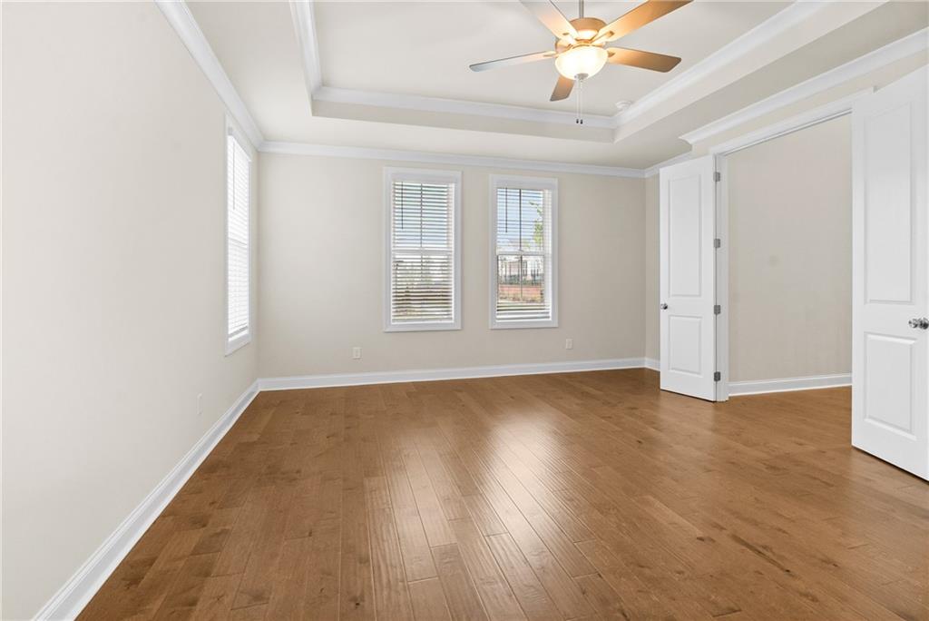 579 Pearl Street Cumming, GA 30040 - Photo 17 of 30 an empty room with wooden floor chandelier fan and windows