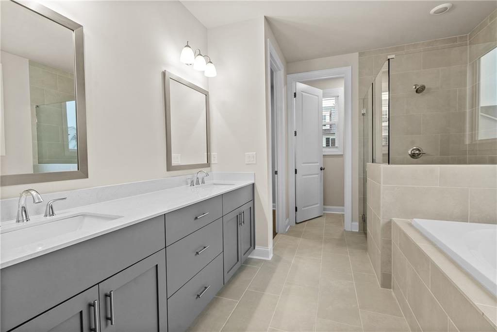 579 Pearl Street Cumming, GA 30040 - Photo 18 of 30 a spacious bathroom with a double vanity sink mirror double and bathtub