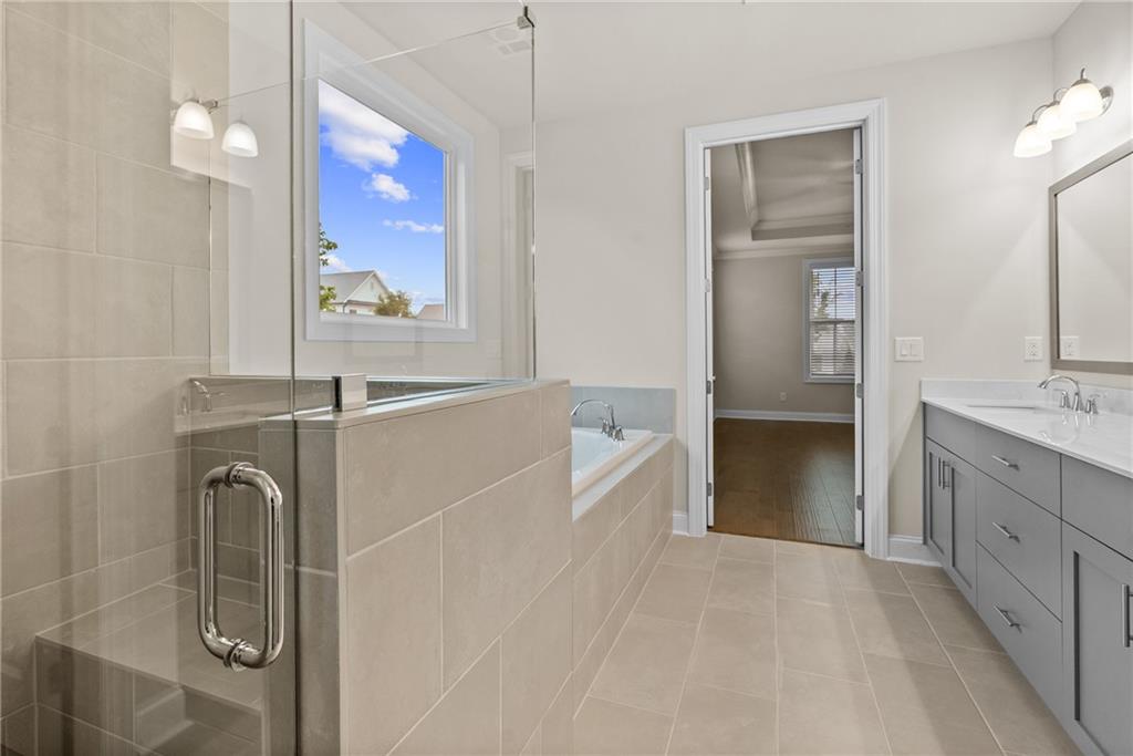 579 Pearl Street Cumming, GA 30040 - Photo 19 of 30 a bathroom with a bathtub sink and mirror