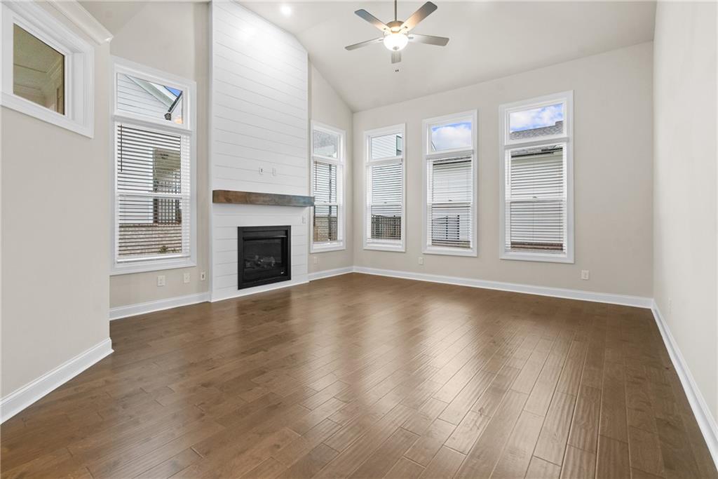 579 Pearl Street Cumming, GA 30040 - Photo 2 of 30 a view of an empty room with wooden floor fireplace and a window