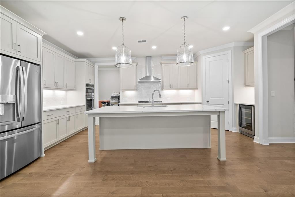 579 Pearl Street Cumming, GA 30040 - Photo 7 of 30 a kitchen with kitchen island white cabinets and stainless steel appliances