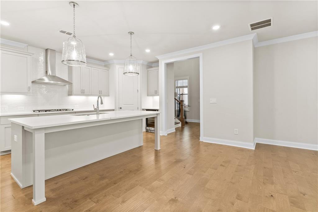 579 Pearl Street Cumming, GA 30040 - Photo 8 of 30 a large white kitchen with kitchen island a sink stainless steel appliances and cabinets