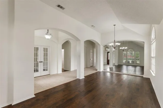 an empty room with wooden floor and outdoor view