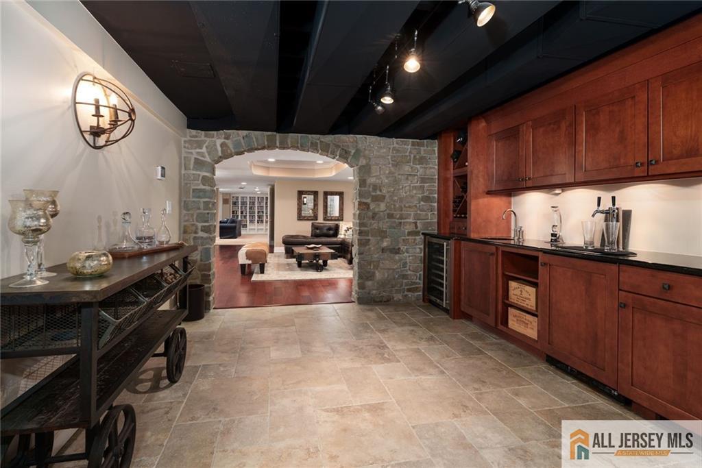 213 Cranbury Neck Road Plainsboro, NJ 08512 - Photo 29 of 52 a view of a kitchen with kitchen island granite countertop a stove top oven a sink with wooden cabinets and glass windows
