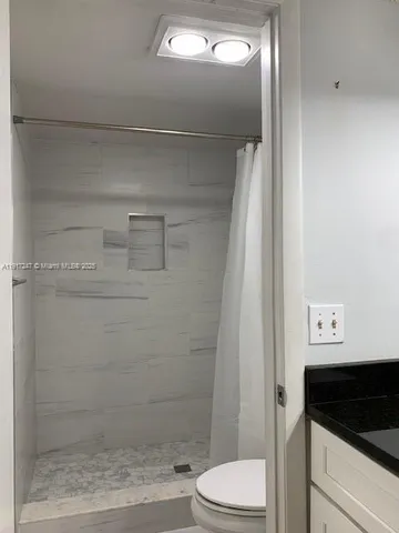 a bathroom with a shower a toilet and a sink