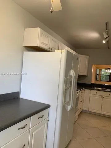a kitchen with granite countertop a refrigerator and a sink