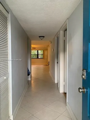 a view of a hallway with wooden shelves