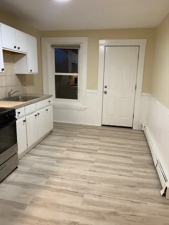a view of a kitchen with wooden floor and electronic appliances