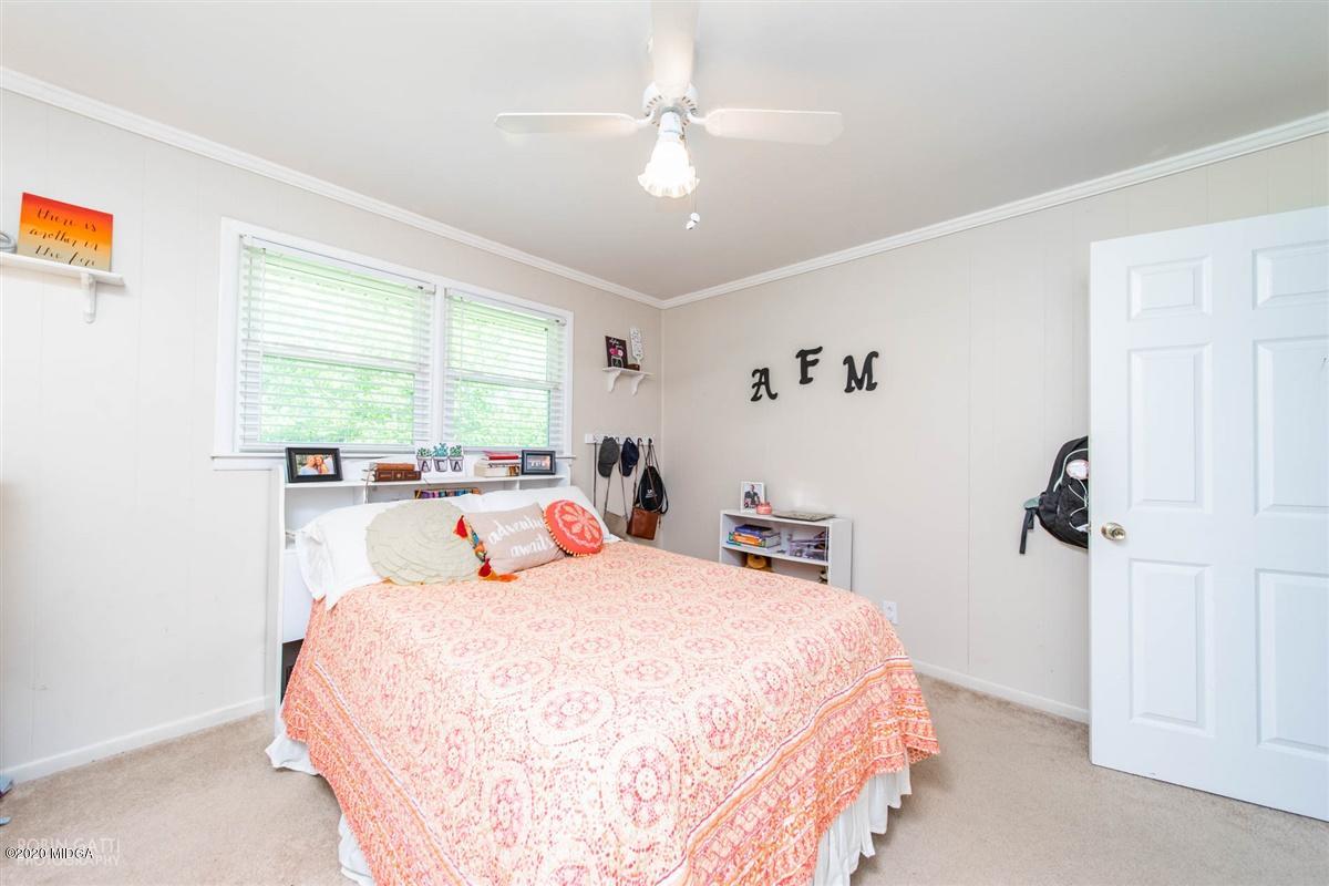 245 Plentitude Church Road Gray, GA 31032 - Photo 14 of 31 a bedroom with a large bed and a chandelier fan