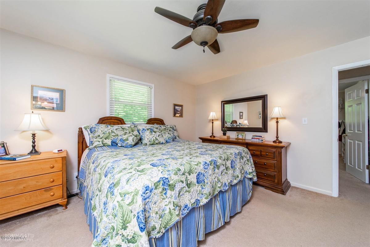 245 Plentitude Church Road Gray, GA 31032 - Photo 16 of 31 a bedroom with a bed and a chandelier