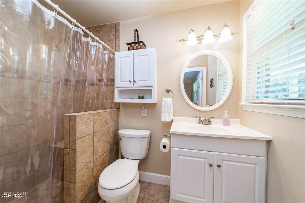 245 Plentitude Church Road Gray, GA 31032 - Photo 17 of 31 a bathroom with a toilet a sink and a mirror