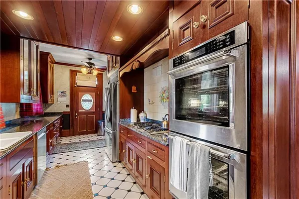 a kitchen with stainless steel appliances granite countertop a stove a sink and a microwave