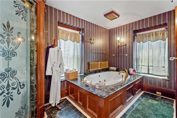 a bathroom with a granite countertop sink a toilet a mirror and shower